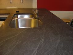 a kitchen counter top with a sink and faucet