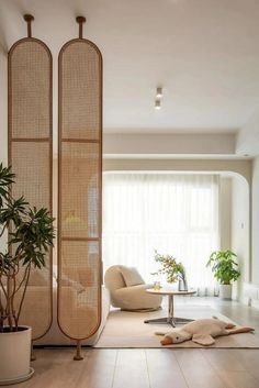 a living room filled with furniture and lots of plants on top of wooden flooring