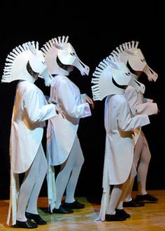 three men dressed in white standing next to each other with paper hats on their heads