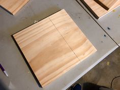 two pieces of wood sitting on top of a table next to a pair of scissors