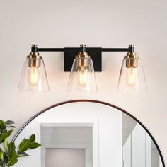 a bathroom vanity light with three clear glass shades