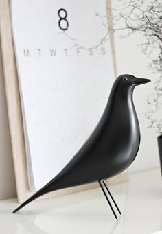 a black bird statue sitting on top of a white table