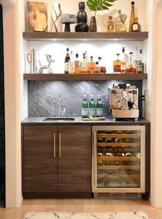 an appliance with bottles and glasses on the shelves above it is displaying wine