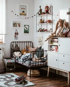 a child's bedroom with toys on the bed and other items in the room