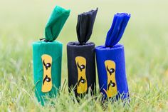 three different colored umbrellas sitting in the grass