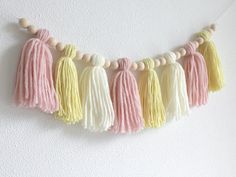 the tasselled garland is hanging on the wall with wooden beads and wood beads