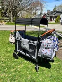 a baby stroller and diaper bag sitting in the grass