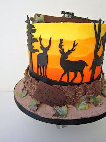 a birthday cake decorated with deer and trees