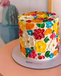 a multicolored decorated cake sitting on top of a table