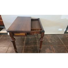 an old wooden desk with drawers on the bottom and one drawer open to show items