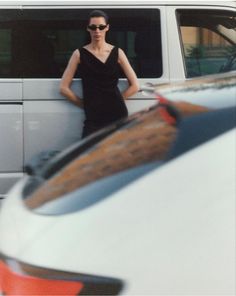 a woman standing next to a white van with her hands on the back of it