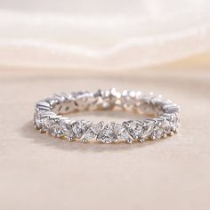 a white gold ring with five diamonds on it, sitting on top of a table