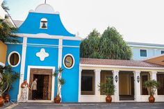 a blue and white building with two people standing outside