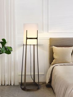 a lamp that is sitting on the floor next to a bed