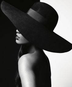 a woman wearing a large black hat