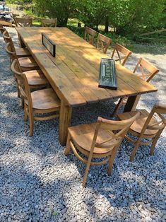 a wooden table and chairs sitting on gravel