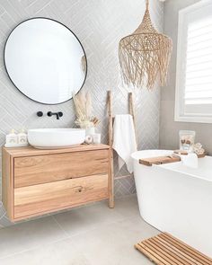 a bathroom with a sink, mirror and bathtub next to a wooden cabinet in front of a window