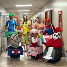 group of people dressed up in costumes and carrying suitcases down a hallway with lockers on either side