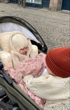 a baby sleeping in a stroller on the street