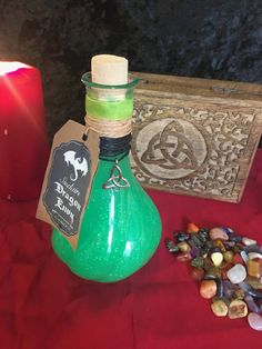 a green bottle sitting on top of a table next to a candle and some candy