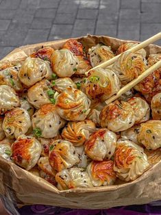 a bowl filled with dumplings and chopsticks on top of a table