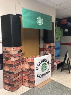 a starbucks coffee stand made out of bricks in an office cubicle with a starbucks sign on it