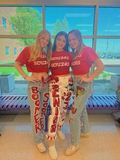 three girls in red shirts and jeans posing for the camera