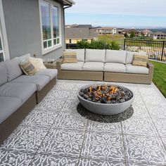 a fire pit sitting in the middle of a patio next to a couch and table