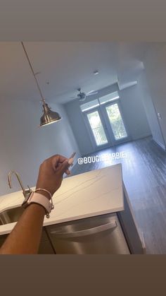 a person is using their cell phone in the middle of an empty kitchen with stainless steel appliances