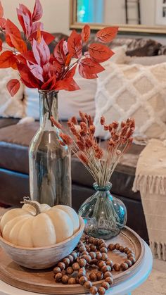 two vases filled with flowers sitting on top of a table next to other items