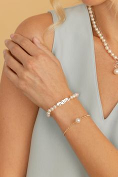 This chic white Freshwater pearl bracelet features 6-6.5mm, AAA quality freshwater cultured pearls. Our pearls are strung and double-knotted with a gorgeous sterling silver centerpiece, with the hand scripted word "mom". This pearl bracelet is affixed with a beautiful sterling silver lobster clasp. Every bracelet comes packaged and shipped in a beautiful jewelry gift box, creating a truly elegant presentation. Silver Pearl Bracelet With Pearl Charm For Mother's Day, Elegant White Name Bracelet For Mother's Day, Adjustable Pearl Bracelet For Mother's Day, Elegant White Name Bracelet For Gift, Elegant Personalized Beaded Bracelets, Classic White Bracelets For Mother's Day, Elegant White Name Bracelet With Letter Beads, Elegant White Name Bracelet, Elegant Beaded Bracelets With Letter Beads For Mother's Day