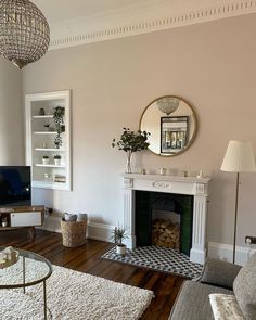 a living room filled with furniture and a fire place under a mirror on the wall