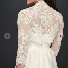 the back of a woman's wedding dress with white lace on top and sleeves