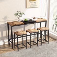 three stools and a table in front of a wall with a poster on it