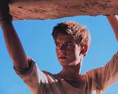 a young man holding onto a large piece of wood