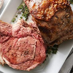 two steaks on a plate with sauce and herbs