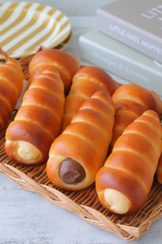 hot dogs wrapped in buns on a wicker tray