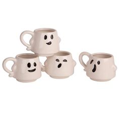 four white coffee mugs with faces painted on the inside one has eyes and two have mouths