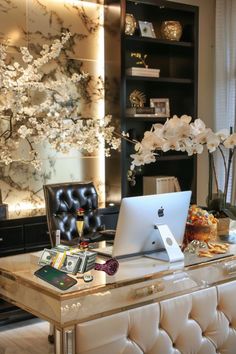 a laptop computer sitting on top of a desk next to a vase with white flowers