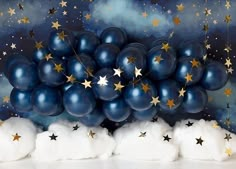 blue balloons with gold stars on them and white fluffy clouds in front of a painting