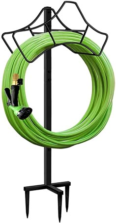 a green hose is attached to a black stand with two wires on it and one wire connected to the pole