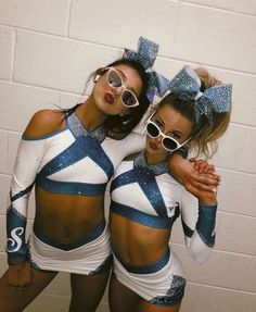 two cheerleaders are posing for the camera