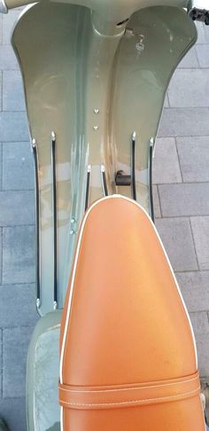 an orange seat on the back of a scooter