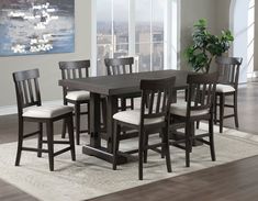 a dining room table with six chairs and a rug