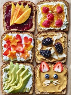 four slices of bread with fruit and vegetables on them, all decorated in the shape of cats