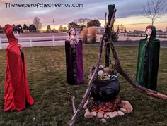 three people dressed in costumes standing around a fire pit