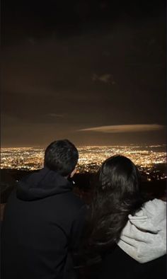 two people are looking at the city lights