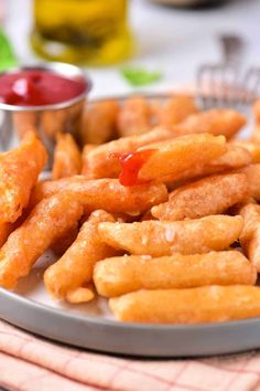 a plate full of french fries with ketchup on the side and dipping sauce