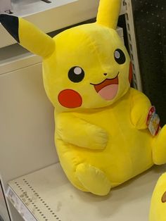 a yellow stuffed pikachu sitting on top of a counter