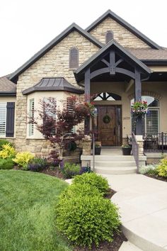 the front entrance to a home with landscaping around it